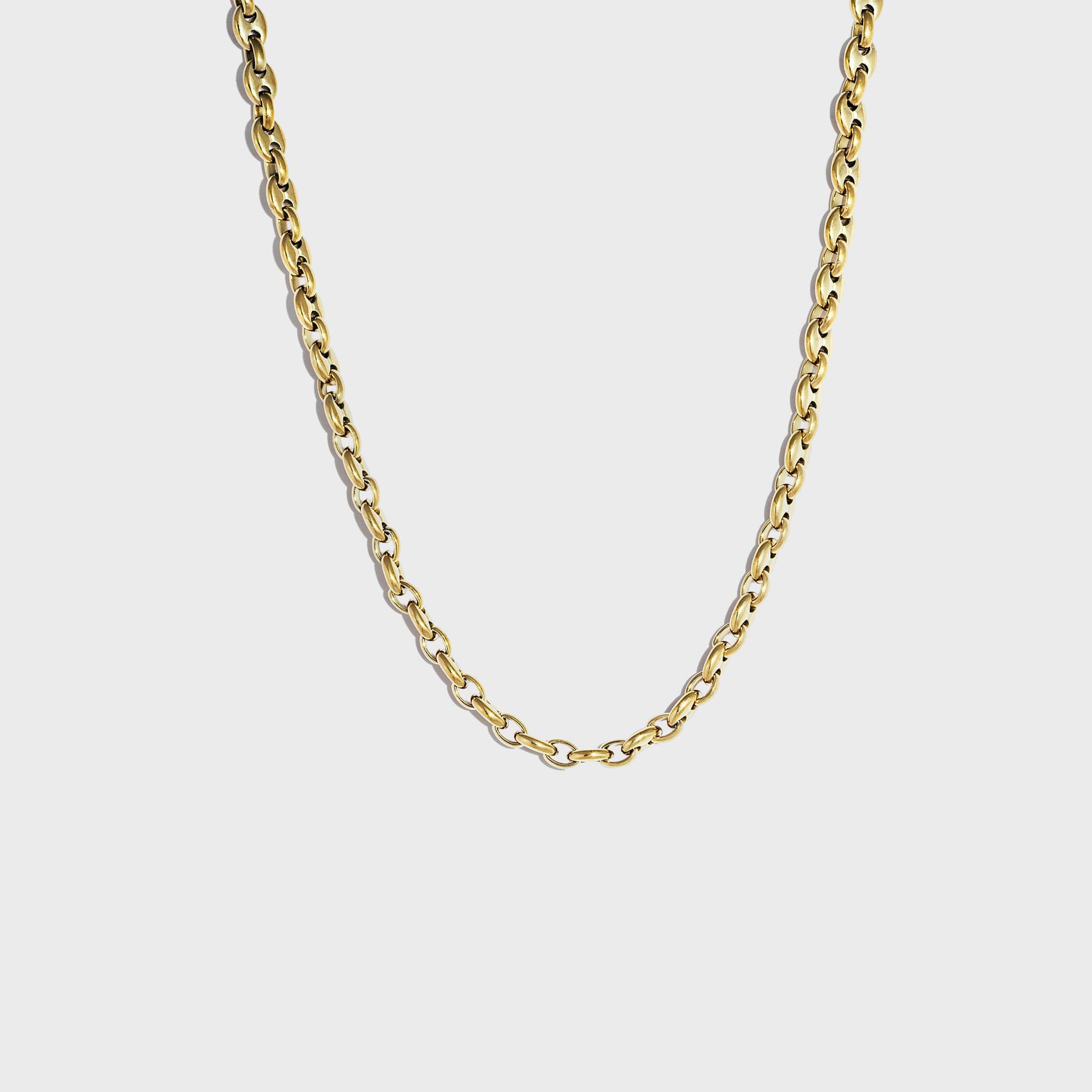 Gold mariner link chain on white background