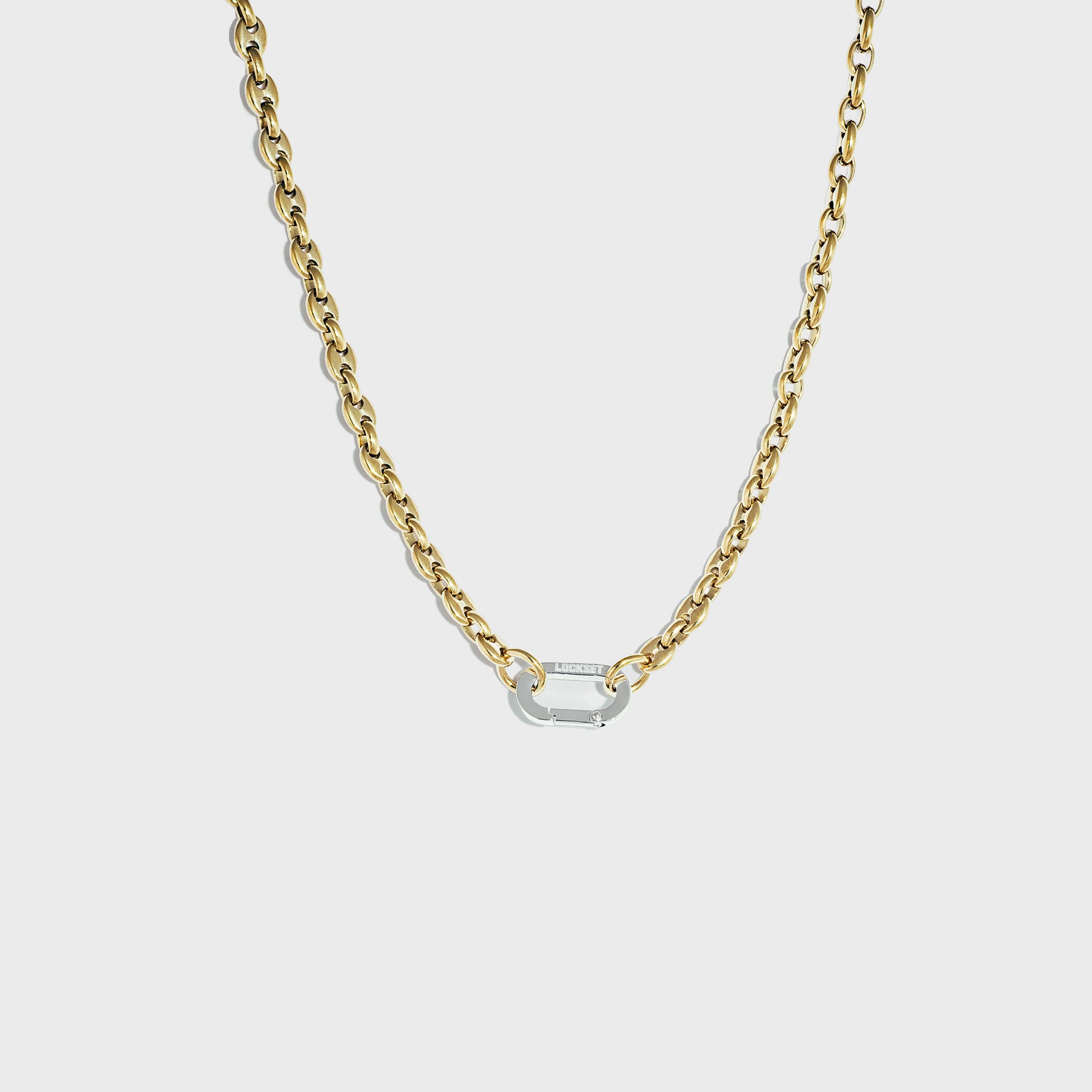Gold mariner link chain with silver carabiner clasp on white background