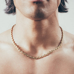 Close-up of man wearing gold mariner-link chain