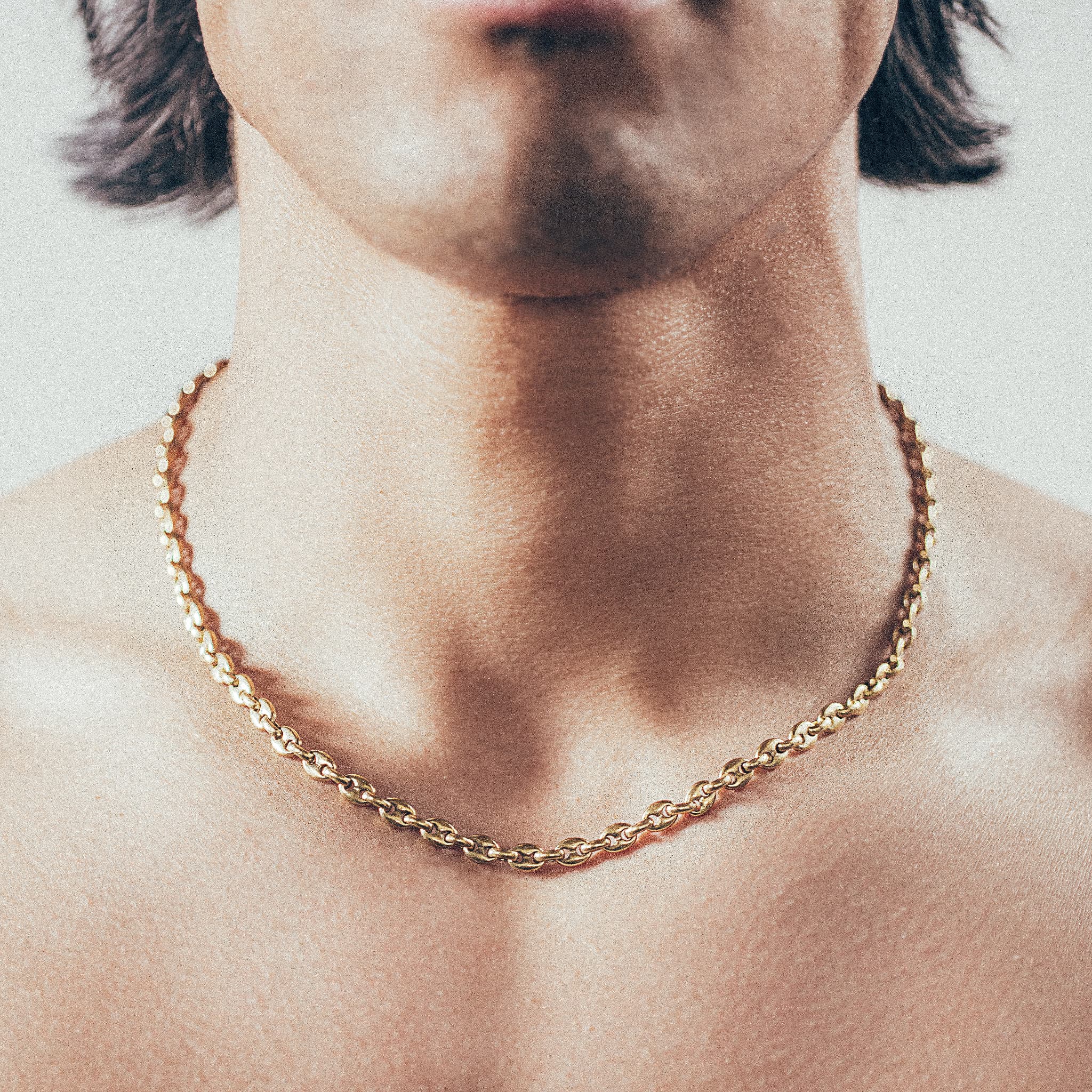 Close-up of man wearing gold mariner-link chain