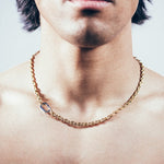 Close-up of man wearing gold mariner chain necklace with silver carabiner clasp