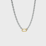 Silver mariner-link chain with gold carabiner clasp on white background