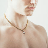 Man wearing gold chain necklace with rectangular six-sided silver tag pendant 