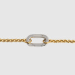 A close-up of a gold chain bracelet featuring a silver-toned carabiner clasp engraved with the brand name 'LOCKSET' on a light gray background.