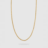 A delicate gold chain necklace with a small, polished rolo link design, suspended against a light gray background.