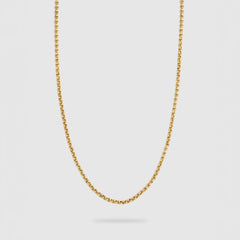 A delicate gold chain necklace with a small, polished rolo link design, suspended against a light gray background.
