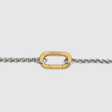 A close-up of a gold-tone carabiner clasp connected to a silver-tone chain, shown against a light gray background. The brand name 'LOCKSET' is engraved on the gold clasp.