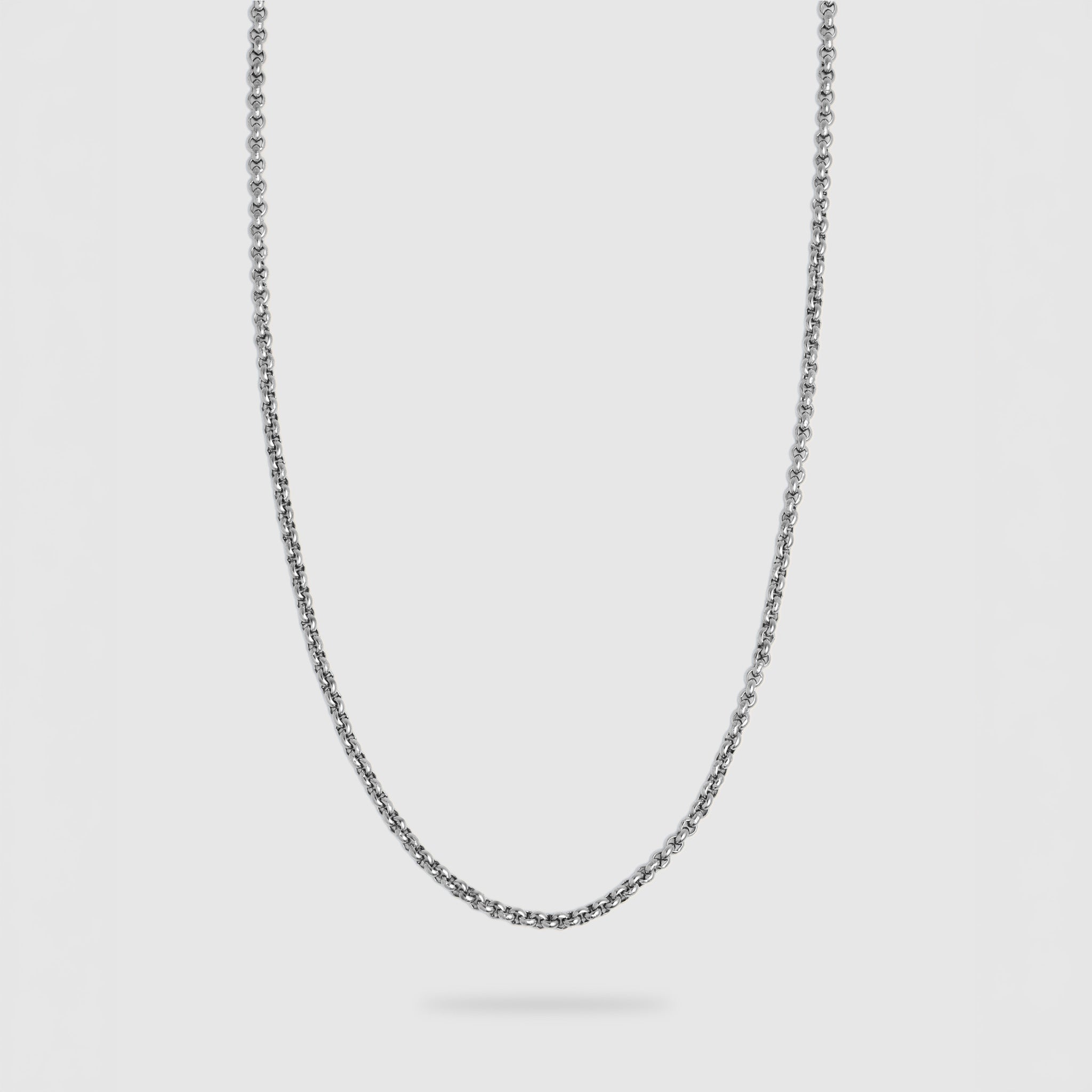 A silver-toned metal chain necklace with a classic box link design, shown hanging in a U-shape against a solid light gray background.