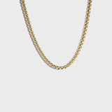 Thick gold rolo chain necklace on white background
