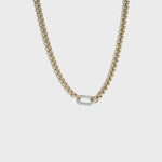 Thick gold rolo chain necklace with silver carabiner clasp on white background