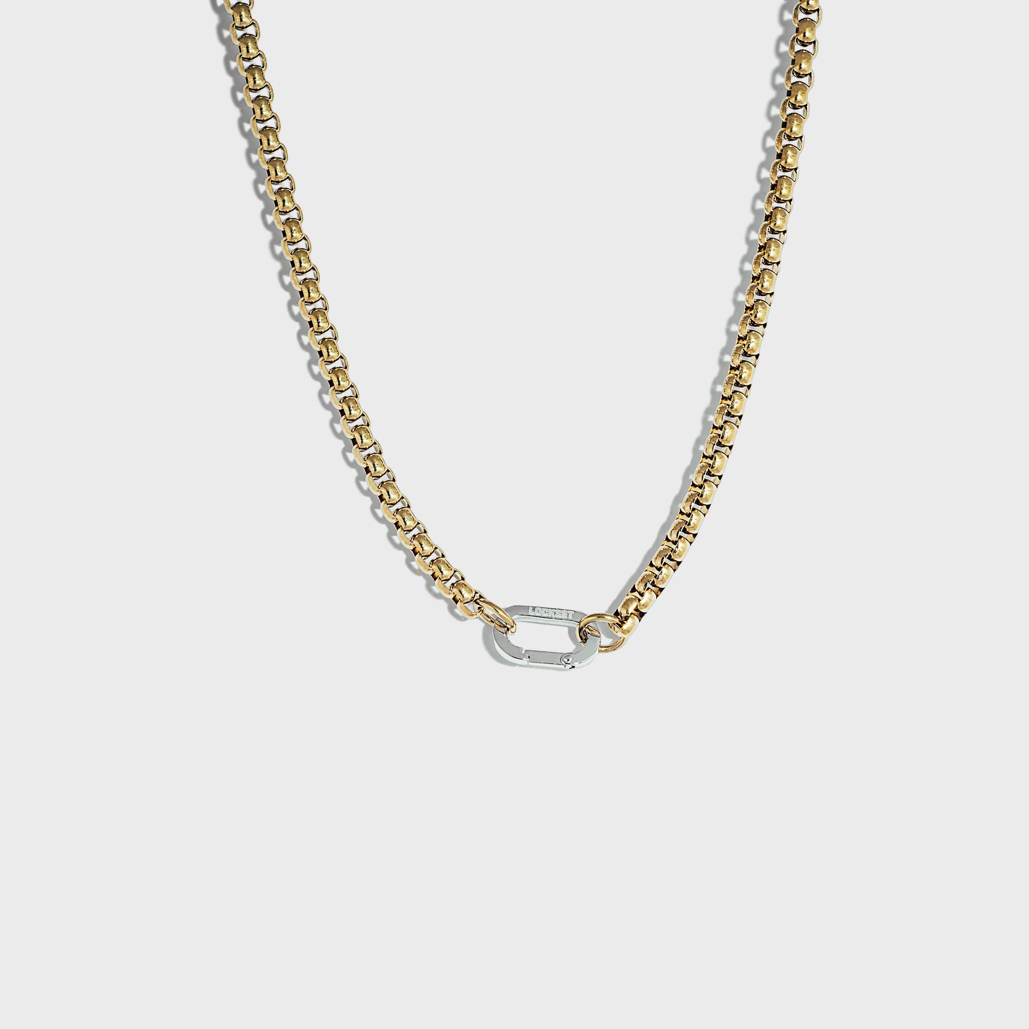 Thick gold rolo chain necklace with silver carabiner clasp on white background