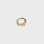 Gold rectangular signet ring on white background