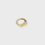 Gold rectangular signet ring on white background