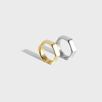 Gold and silver hex-style rings on white background