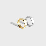 Gold and silver hex-style rings on white background