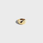 Gold circular signet ring on white background