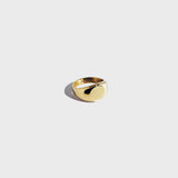 Gold circular signet ring on white background